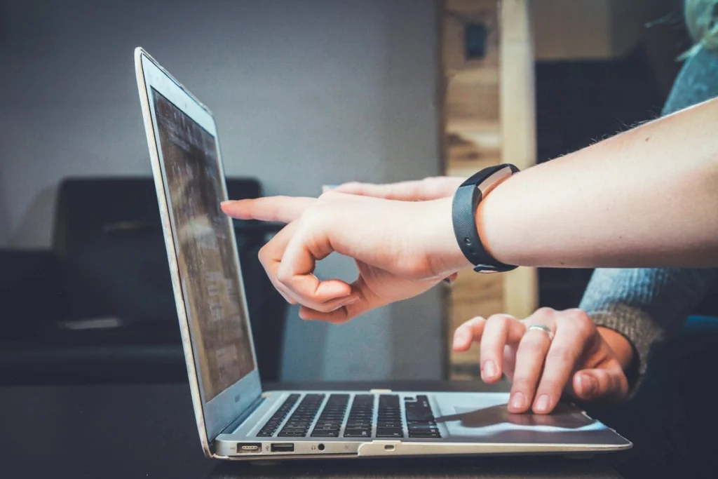 Deux personnes pointent l'écran d'un ordinateur portable pendant un atelier de travail