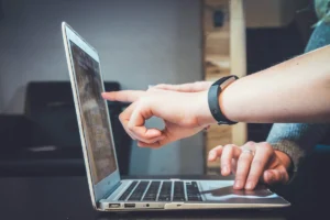 Deux personnes pointent l'écran d'un ordinateur portable pendant un atelier de travail