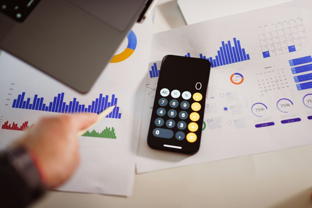 Calculatrice posée à côté d'un ordinateur portable pour estimer le budget d'un projet d'intelligence artificielle