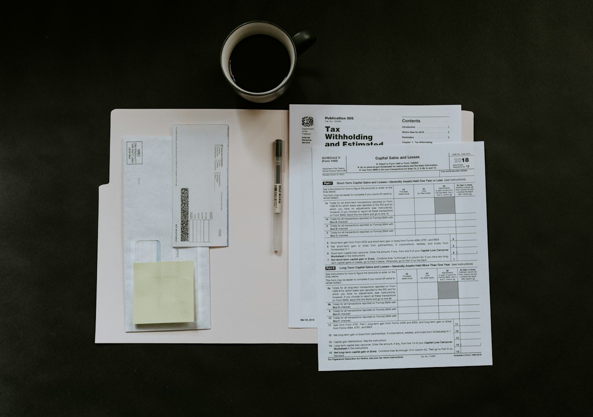 Dossier de documents administratifs posés sur un bureau sombre à côté d'une tasse de café